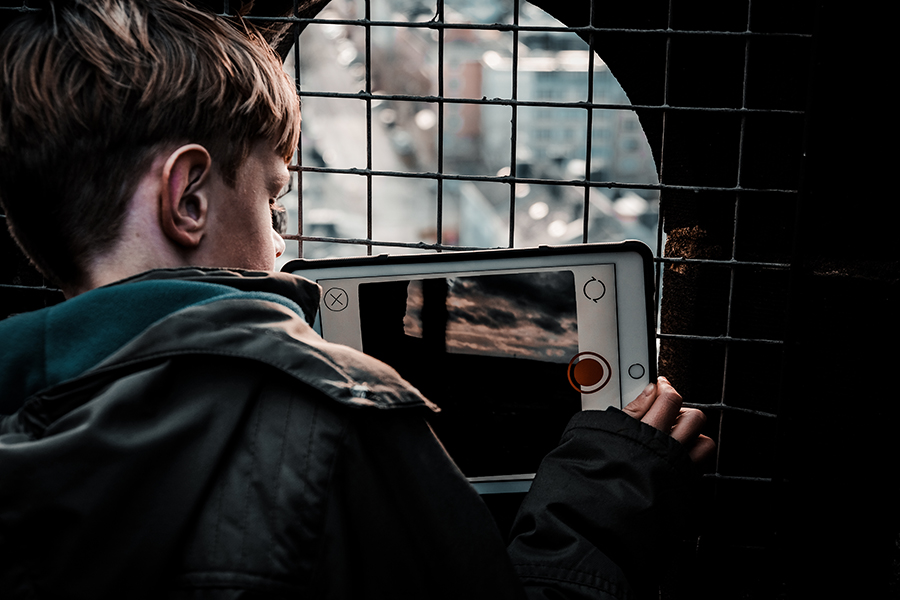 Junge fotografiert mit Tablet vom Kirchturm herab